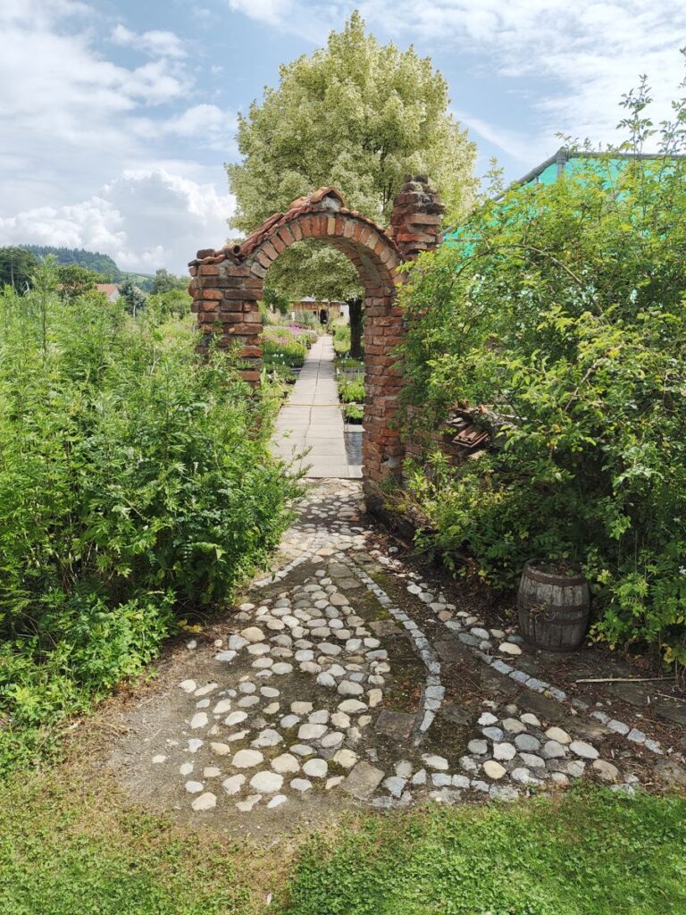 gemauerter Torbogen mit sichtbaren Klinkerziegeln und Wegbelag aus Feldsteinen